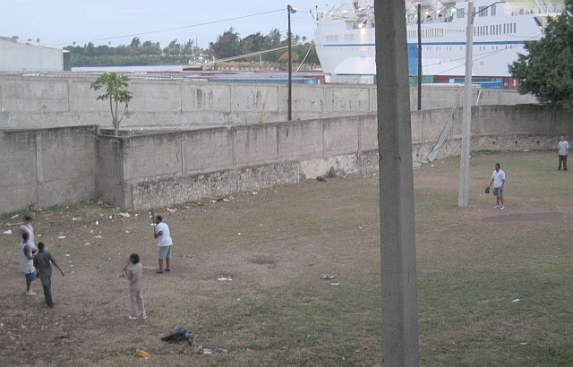 Guys playing baseball near the ocean